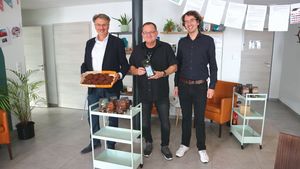 Bürgermeister Manfred Ockel, Thorsten Schreiner und Klimaschutzbeauftragter Maximilian Barth präsentieren einige der fairen Produkte, die durch die Stadt Kelsterbach beworben werden.