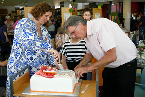 Bibliotheksleiterin Meike Betzold (l) und Bürgermeister Manfred Ockel schneiden die Geburtstagstorte an.